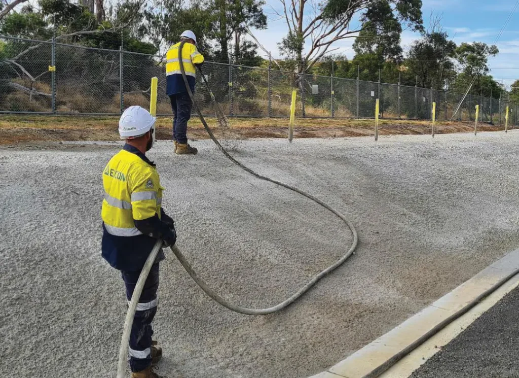 Construction workers pulling hoses.