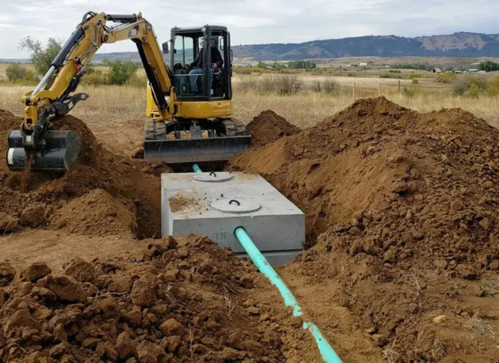 Excavator installing septic tank.